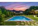 Inviting rectangular pool surrounded by a stone patio at sunset at 5527 Carmel Park Dr, Charlotte, NC 28226