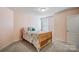 Cozy bedroom featuring warm pink walls, soft carpet, and classic wood-framed bed at 109 Belfry Loop, Mooresville, NC 28117