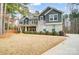 Striking two-story home featuring a brick and shingle exterior, mature trees and a well-manicured lawn at 109 Belfry Loop, Mooresville, NC 28117