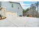 Spacious two-car garage with an adjacent parking pad and wooded views at 109 Belfry Loop, Mooresville, NC 28117