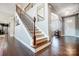 Elegant staircase with dark wood floors and wrought iron railing, leading to the upper level at 109 Belfry Loop, Mooresville, NC 28117