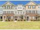 New townhomes with brick and siding exteriors, manicured lawns, and professional landscaping create inviting curb appeal at 114 Marron Dr, Indian Trail, NC 28079