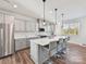 Modern kitchen with stainless steel appliances, gray cabinetry, marble backsplash, and a large center island with pendant lights at 114 Marron Dr, Indian Trail, NC 28079