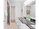 Clean, bright bathroom featuring white cabinets, black countertop, white tiling, and a glass door shower at 115 Union Chapel Dr, Mooresville, NC 28117