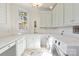 Well-lit laundry room with ample counter space, white cabinets, and modern appliances at 115 Union Chapel Dr, Mooresville, NC 28117