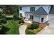 Back exterior of home with brick-lined patio and seating area surrounded by lush landscaping at 115 Union Chapel Dr, Mooresville, NC 28117