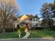 Charming two-story brick home with lush landscaping and a winding walkway to the front door at 115 Union Chapel Dr, Mooresville, NC 28117