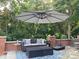 Outdoor seating area with umbrella, blue patterned rug, and brick retaining wall at 115 Union Chapel Dr, Mooresville, NC 28117