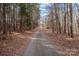 Long gravel driveway leading to a home through a wooded area at 11745 Stokes Ferry Rd, Gold Hill, NC 28071