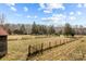 Open field with wooden fence and rustic barn at 11745 Stokes Ferry Rd, Gold Hill, NC 28071