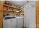 Bright laundry room, washer, dryer, and built-in shelving at 11745 Stokes Ferry Rd, Gold Hill, NC 28071