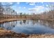 Picturesque pond reflecting the surrounding trees at 11745 Stokes Ferry Rd, Gold Hill, NC 28071