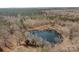 Aerial view of a serene pond nestled in the woods at 11745 Stokes Ferry Rd, Gold Hill, NC 28071