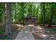 Convenient storage shed nestled in a wooded backyard setting at 119 Barton Pl, Mooresville, NC 28117