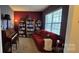 Comfortable living room with deep red walls, bookshelves, and a cozy red sofa at 121 Mackinac Dr, Mooresville, NC 28117