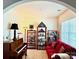Inviting living room features a piano, bookshelves, and a comfortable red sofa, creating a cozy and stylish space at 121 Mackinac Dr, Mooresville, NC 28117