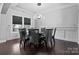 Modern dining room with dark hardwood floors, stylish light fixture, and seating for eight at 12904 Vermillion Xing, Huntersville, NC 28078