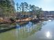 Lakefront property with a house, dock and gazebo, surrounded by lush trees at 168 Tanglewood Cv, Belmont, NC 28012