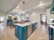 Spacious kitchen with teal cabinetry, island, and stainless steel appliances at 168 Tanglewood Cv, Belmont, NC 28012