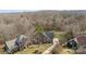 Aerial view of a two-story brick home, neighborhood, and wooded area at 2050 Stoney Creek Nw Dr, Concord, NC 28027