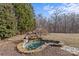 Backyard pond with rock waterfall and natural landscaping at 2050 Stoney Creek Nw Dr, Concord, NC 28027