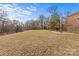 Landscaped backyard, stone patio, and deck, backing to wooded area at 2050 Stoney Creek Nw Dr, Concord, NC 28027