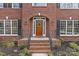 Charming brick home entrance with an arched doorway, black shutters and manicured landscaping at 2050 Stoney Creek Nw Dr, Concord, NC 28027