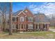 Stunning two-story brick home with a well-manicured lawn and mature trees at 2050 Stoney Creek Nw Dr, Concord, NC 28027