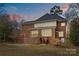 Brick house with a large deck and a sunroom, at dusk at 2050 Stoney Creek Nw Dr, Concord, NC 28027