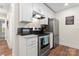 Modern kitchen with white cabinets, granite countertops, and stainless steel appliances at 209 S Gregory St, Lancaster, SC 29720