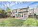 A wide angle view of the backyard with a patio and lush green lawn, surrounded by a charming fence at 2327 Axford Ln, Matthews, NC 28105