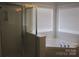 Bright bathroom featuring a glass shower and a corner soaking tub at 2327 Axford Ln, Matthews, NC 28105