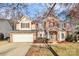 Two-story brick and siding home featuring a two-car garage, manicured lawn, and a welcoming front porch at 2327 Axford Ln, Matthews, NC 28105