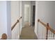 Bright hallway featuring neutral carpeting, white trim, and wooden railing at 2327 Axford Ln, Matthews, NC 28105