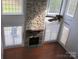 Living room featuring stone fireplace, hardwood floors, and large windows at 2327 Axford Ln, Matthews, NC 28105