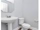 Simple powder room featuring gray walls, a pedestal sink, and standard toilet at 2327 Axford Ln, Matthews, NC 28105