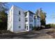 Exterior view of the building showcasing the unit windows, covered patios and car parking at 2501 Roswell Ave # 303, Charlotte, NC 28209