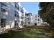 Exterior angle of the white building showcasing the lawn, mature trees and unit windows at 2501 Roswell Ave # 303, Charlotte, NC 28209