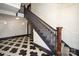 Elegant entryway featuring classic black-and-white tile flooring and a staircase with a dark wood banister at 2501 Roswell Ave # 303, Charlotte, NC 28209