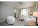 Bright living room with white furniture, light gray walls, and a view into an adjacent sunroom through French doors at 2501 Roswell Ave # 303, Charlotte, NC 28209