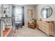 Bedroom with round mirror, gray rug, accent chair, and bright natural light at 252 Laura Elizabeth Ln, Clover, SC 29710