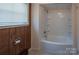 Bathroom featuring a tiled tub and shower, as well as wooden wall trim and flooring at 2905 Maryland Ave, Kannapolis, NC 28083