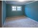 This bedroom features neutral carpet, blue painted walls, and a window for natural light at 2905 Maryland Ave, Kannapolis, NC 28083