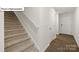 Carpeted staircase with a simple white handrail at 2953 Penninger Cir, Charlotte, NC 28262