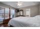 Bedroom includes a ceiling fan, television, and large windows overlooking a deck at 298 Upper Stanley Rd, Stanley, NC 28164