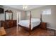 Bedroom boasts hardwood floors, a four-poster bed, and classic dresser at 298 Upper Stanley Rd, Stanley, NC 28164