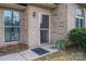 Inviting brick home entrance with a charming welcome mat and a secure screen door at 298 Upper Stanley Rd, Stanley, NC 28164