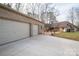 Detached garage with a long driveway and large stamped concrete patio with outdoor furniture at 298 Upper Stanley Rd, Stanley, NC 28164