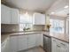 Well-lit kitchen with white cabinets and stainless steel dishwasher, sink beneath the window at 298 Upper Stanley Rd, Stanley, NC 28164