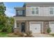 Two-story townhome with gray siding, stone accents, and a two-car garage at 33 Woodsdale Se Pl, Concord, NC 28025